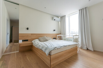 Interior photo large bedroom with large bed and small cot family bedroom.