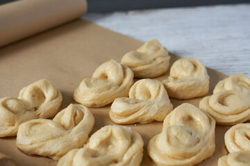 Close-up of buns on baking paper with rolling pin.