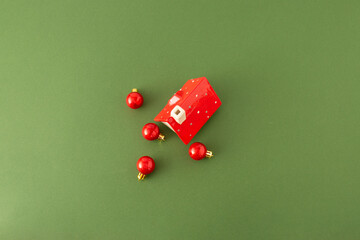 Red roof and Christmas tree decoration on green background. Holiday celebration concept.