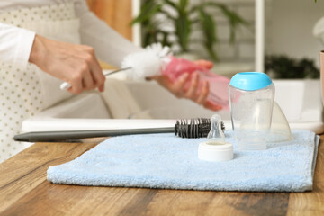 Clean baby bottle drying on towel in kitchen, closeup