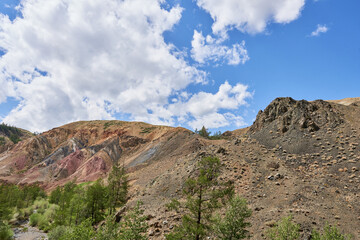 Landscape view of colorful mountains and blue sky with white clouds.