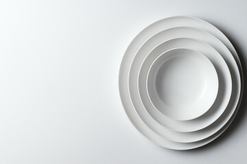 Obraz premium Stack of white plates on a light background