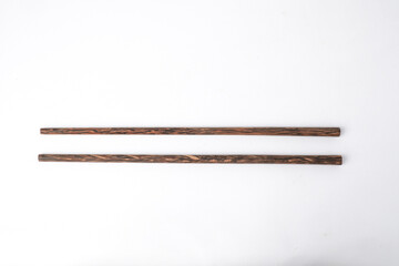 Close-up photo of oriental wooden chopsticks isolated on white background. High angle, Flat Lay Setup.