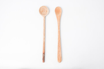 Close-up photo of wooden circular teaspoon and long small spoon isolated on white background. High angle, Flat Lay, Bundling Setup.