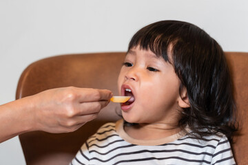 mother feeding liquid medicine to sick toddler baby with spoon