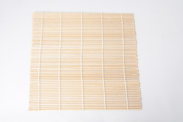 Close-up photo of Japanese woven bamboo mat or makisu. Isolated over white background. Shot on flat lay high angle setup.