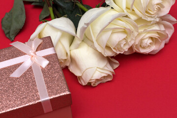 Postcard. White roses on a blue background with a pink gift box. Congratulations on March 8, Valentine's Day, Mother's Day, Birthday, Anniversary, Easter, Wedding, Teacher's Day, to women.