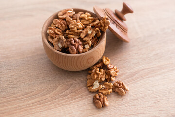 Walnuts kernels on dark desk with color background, Whole walnut in wood vintage bowl.