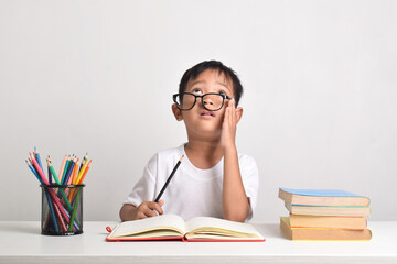Portrait of an Asian boy studying isolated on a white background. The child is dizzy with his...
