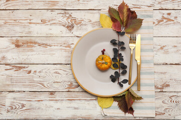 Beautiful table setting with autumn decor on light wooden background