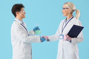 Chemists shaking hands on blue background