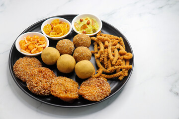 Indian festival food. Diwali Special sweet and salty snacks include Chakli, coconut laddu, besan ladu, poha and sabudana chivda, corn or maka mixture, Anarasa. Diwali Faral from Maharashtra, India.