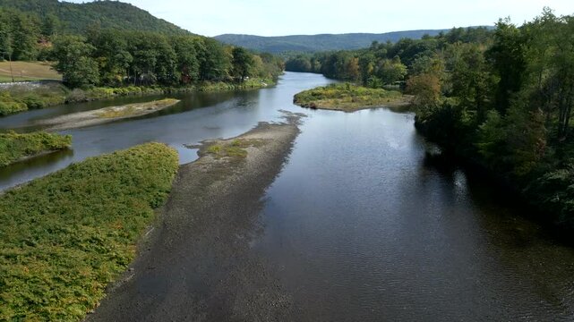 Aerial dolly soars above Mohawk Trail by Deerfield River in Western Massachusetts New England USA