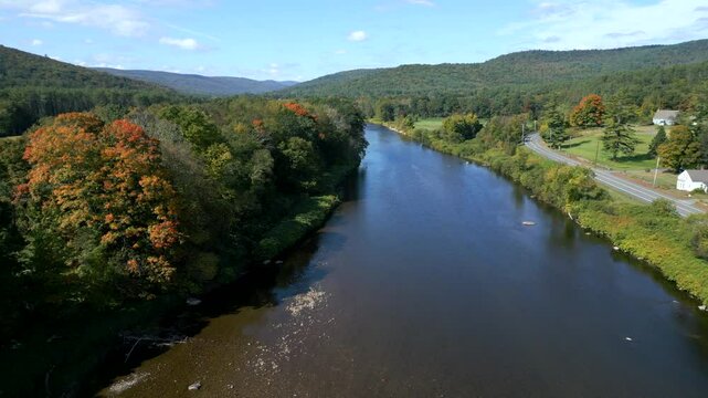 Drone rises following bend in river of Mohawk Trail by Deerfield River in Western Massachusetts New England USA