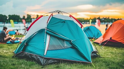 A turquoise camping tent pitched in a grassy field
