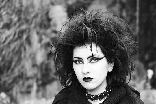 Portrait of Dark gothic fashion youg woman with black makeup, black lipstick and nose piercing. Italian beautiful brunette girl. Dark lady. Dark girl. Trad goth girl. Black and white photo. Close-up
