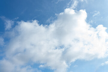 Fluffy white clouds drift across a clear blue sky, painting a breathtaking landscape of nature's beauty