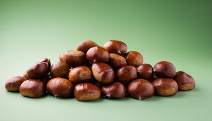 Freshly Harvested Chestnuts in a Winter Bounty Pile on a Matte Green Background. Perfect for Seasonal Cooking, Holiday Baking, or Rustic Decor Concepts in Cool Toned Natural Settings