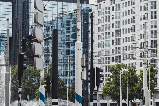 An urban scene packed with modern trams, street poles, and surrounding glassfronted buildings highlights the hustle and bustle typical of city environments.