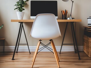 A white chair sits in front of a wooden desk with a computer, lamp and plant.