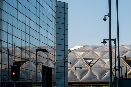 A modern urban scene with glass buildings reflecting each other, illustrating the complexity and beauty of contemporary architecture alongside urban infrastructure elements in London UK