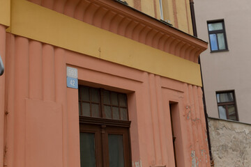 The structure is a vibrant pink and yellow building, which features a prominent blue sign affixed...