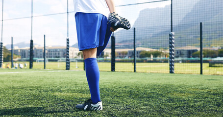 Legs, person and stretching for fitness on soccer field for sports game, exercise and warm up challenge. Athlete, player and prepare for football competition, workout performance and start tournament © AzeemudDeen/peopleimages.com
