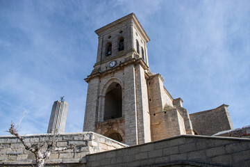 Obraz premium Iglesia con campanario de Pampliega, España y casas rústicas de piedra