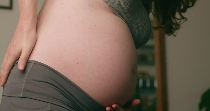 Pregnant Woman Holds Her Baby Bump and Experiences Back Pain in the Third Trimester
