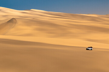 Sandwich Harbour in Namibia mit einem 4x4 Fahrzeug - eine Landschaft zwischen Dünen, Wüste und dem Atlantik