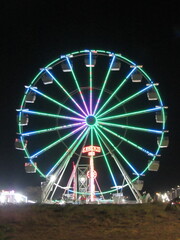 Ferris wheel all lit up in an amusement park forming a mosaic of lights