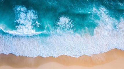 Obraz premium Aerial View of Turquoise Ocean Waves Crashing on Sandy Beach