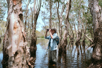 A tourist with a camera travels in the forest. Travel concept