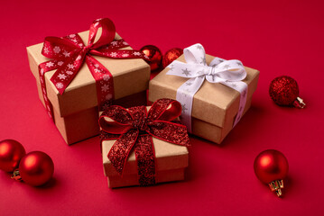Christmas gift boxes with red balls on red background.