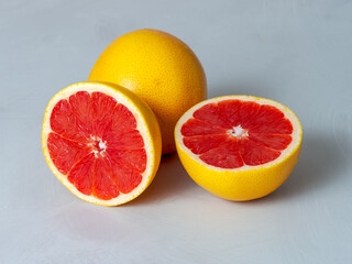 grapefruit group of fruits cut in half, red interior light background, red – bitter, sour, juicy taste