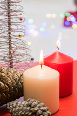 Christmas decoration with burning candles and Christmas tree on a red background.