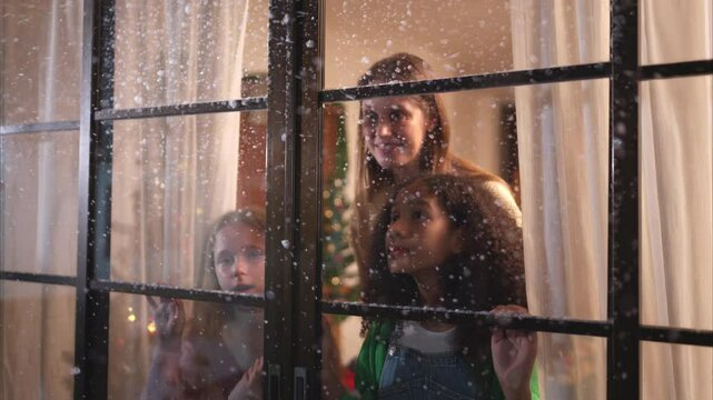 Mother and teen girl on Christmas night with the first snowfall