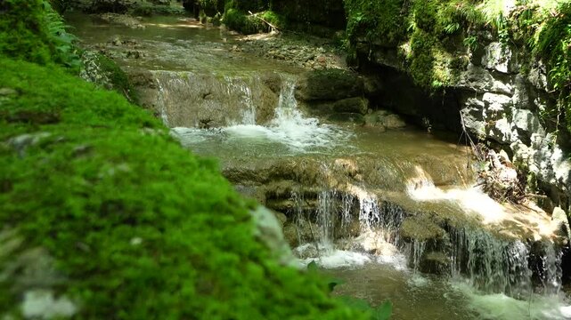 Slow-motion of the waterfall of Verena Gorge Hermitage with mossy rocks on a sunny day