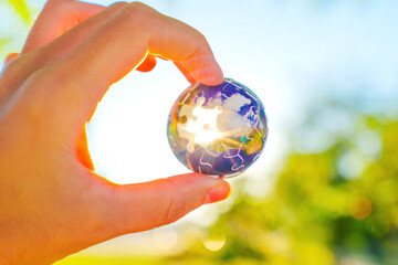 Hand Holding 3d Jigsaw Puzzle Globe with Sunlight Glow