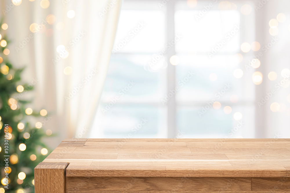 Wall mural blur christmas tree and window interior background with empty wooden table in front for display prod