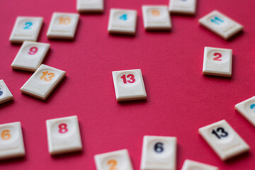 white chip with number 13 in the center surrounded by chips with other numbers on red background, loneliness and failure concept