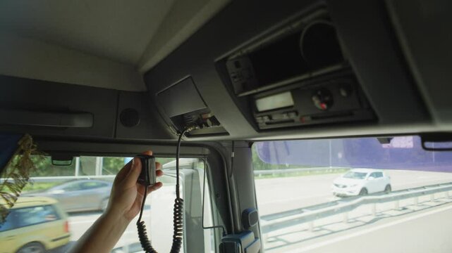 Close-up of a truck driver putting down a walkie-talkie after negotiations. High quality 4k footage