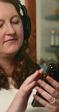 Pregnant Woman Relaxing on Sofa, Listening to Music on Smartphone with Headphones