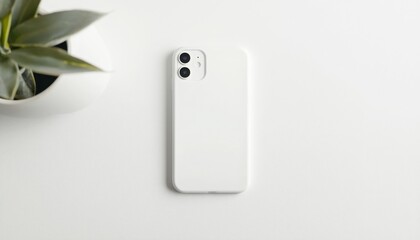 A minimalistic white smartphone rests on a clean surface, with a green plant in the background, creating a serene and modern aesthetic.