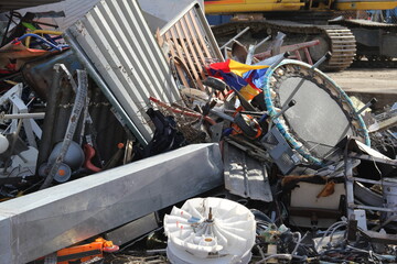 Scrap metal trash at recycling center. The waste includes household appliances, roofing iron and a...