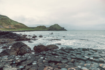Vintage film effect photo of Giant Causeway in Northern Ireland, featuring hexagonal basalt columns...