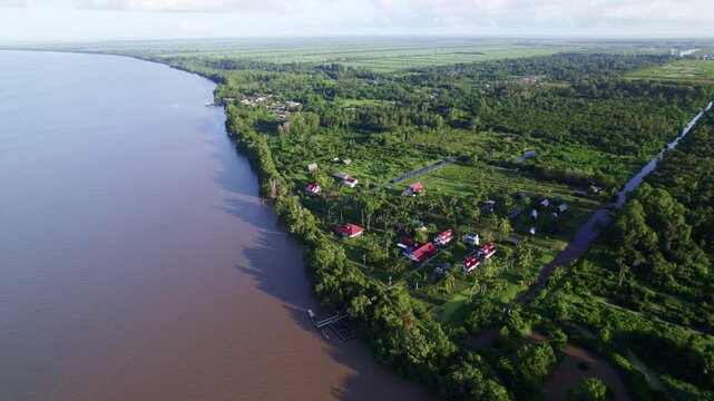 Drone flyover Frederiksdorp over Commewijne river, Suriname rainforest, sky reveal