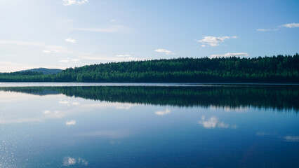 A landscape view of a freshwater forest lake. Quiet water and a calm natural atmosphere. Beauty is...