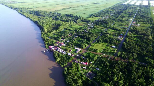 Fly over rural village by commewijne river, Johan and Margaretha and Rust and Werk plantation, sky reveal, Suriname