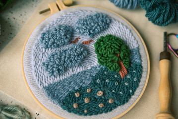 Closeup of punch needle embroidery with rich texture and different stitches in a frame.